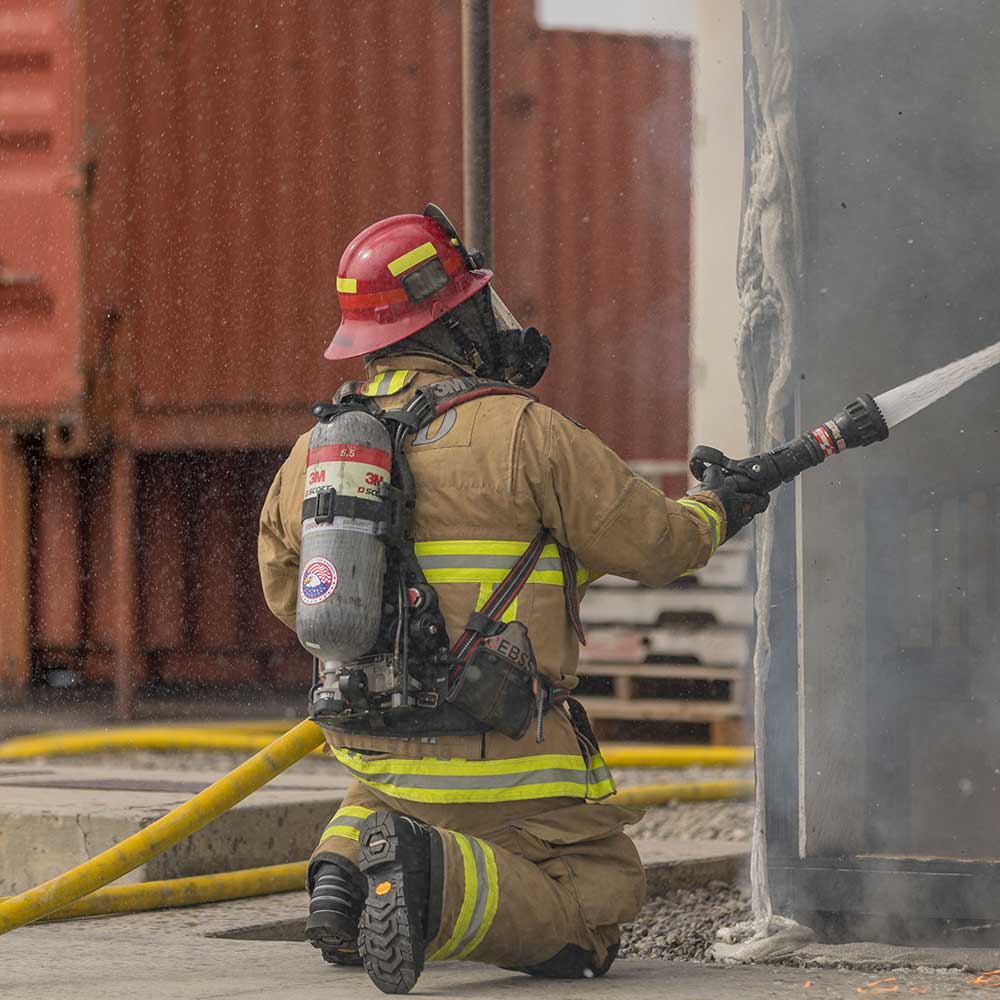 fire fighter putting out blaze in truck